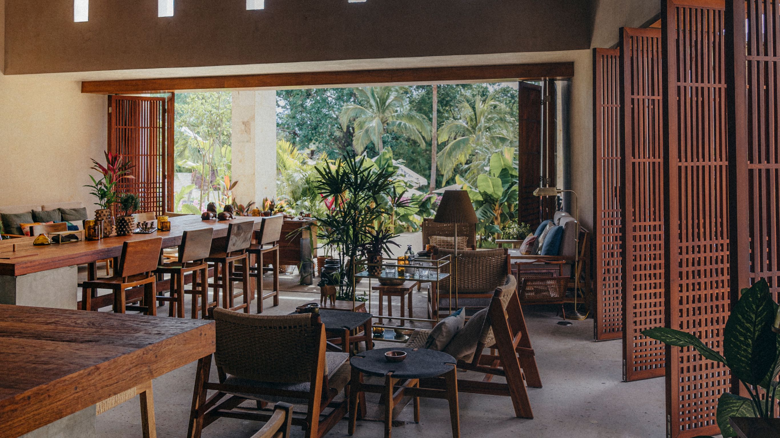 Vista del interior de Zapote Bar con mesas de comedor, sofás y decoración